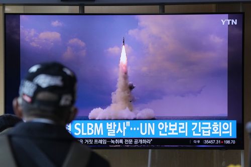 Un uomo guarda uno schermo televisivo che mostra l'immagine di un missile balistico nordcoreano lanciato da un sottomarino durante un telegiornale alla stazione ferroviaria di Seoul, Corea del Sud.