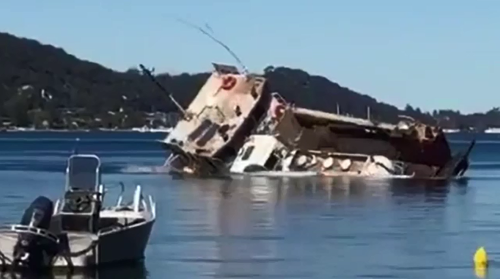 A barge has capsized, spilling thousands of litres of waste into the water at Great Mackarel Beach.