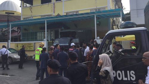  Malaysian police truck waits outside an Islamic religious school following a fire on the outskirts of Kuala Lumpur. (AAP)
