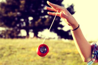 Female hand playing with a yoyo in motion.