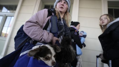 A woman carrying her dog, arrives at Przemysl, southeastern Poland, near the border with Ukraine.