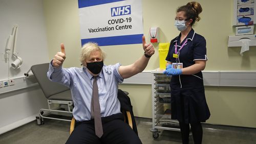 Le Premier ministre britannique Boris Johnson fait des gestes après avoir reçu la première dose de vaccin AstraZeneca