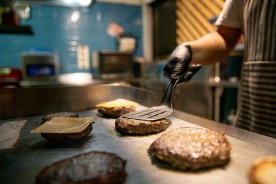 Close-up on a chef preparing burgers at a restaurant  fast food concepts