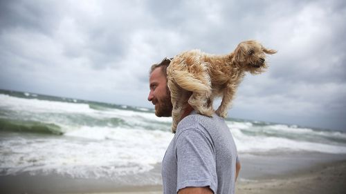 A man and his dog Kermit visit the beach as Hurricane Matthew approaches the area. (AFP)