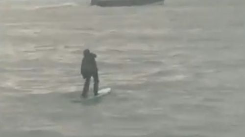 This man dressed in a suit appeared to be going to work on a paddle-board. Picture: Supplied