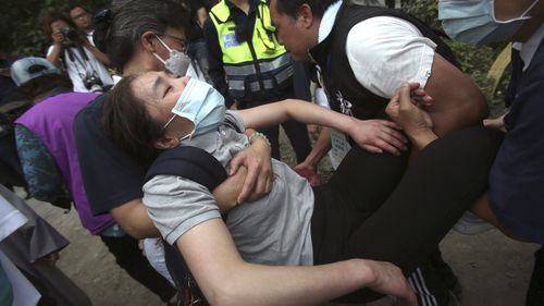 A distressed woman is carried away as families mourn for the victims in a train accident near Taroko Gorge in Hualien, Taiwan 