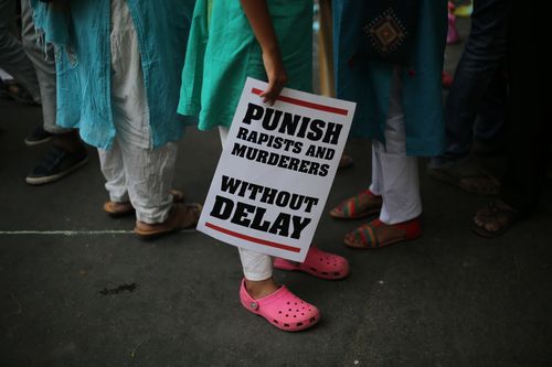 An Indian protestor stands with a placard during a protest against two recently reported rape cases last month. (AAP)