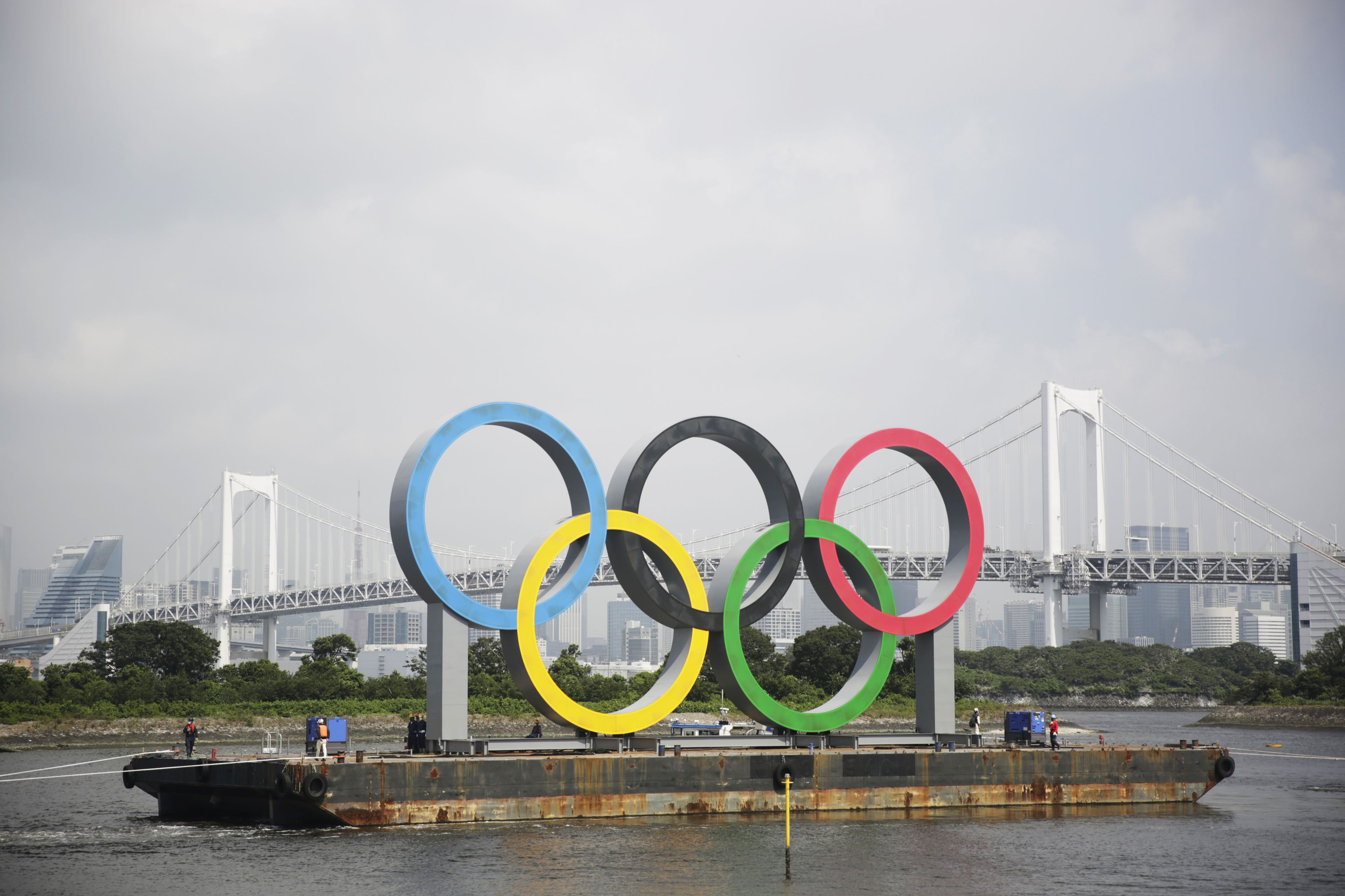 Tugboats move a symbol installed for the Olympic and Paralympic Games in Tokyo.