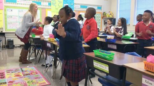 A US teacher has been praised after a video was posted online showing her leading her class in a pre-lesson dance routine. (Facebook/St. John Catholic School)