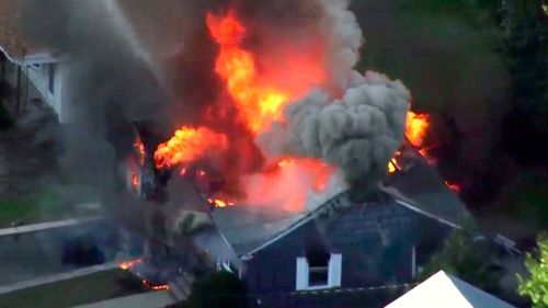 In this image take from video provided by WCVB in Boston, flames consume a home.