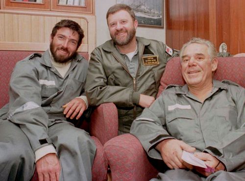 Raydon Gates, centre, with Thierry Dubois, left, and Tony Bullimore in the captain's cabin aboard HMAS Adelaide in 1997. (Photo: AAP).