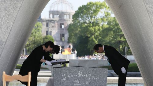 Hiroshima Mayor Kazumi Matsui (R) offers a new list of A-bomb dead, people who died since last year's anniversary from the side effects of radiation, during the 72nd anniversary memorial service for the atomic bomb victims at the Peace Memorial Park in Hiroshima (STR / JIJI PRESS / AFP).