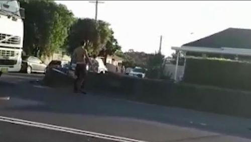 Footage shows a man pulling a chainsaw out of his car and revving it towards bystanders. (Supplied)