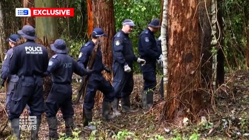 Officers form a human chain to remove debris from the search area.