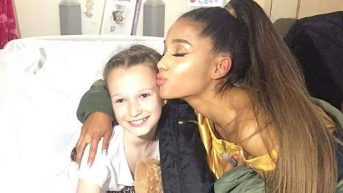 Ariana Grande kisses one of her fans. (Twitter)