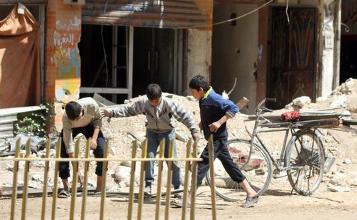 Children play in the streest of Zamalka, in Eastern Ghouta, on April 8, 2018. (AAP)