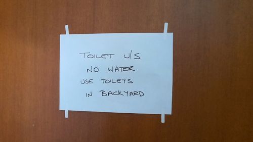 A sign posted on a door at Mudgee's Fire and Rescue NSW station informing firefighters there is no water and to use portable toilets in the backyard.