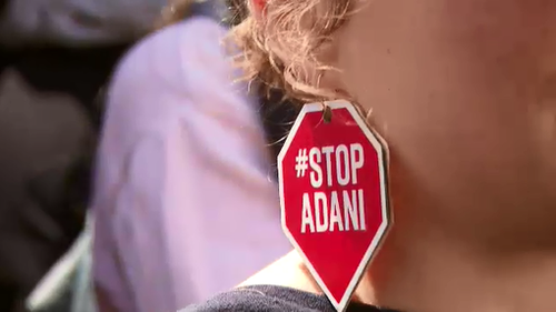 A protester wearing "Stop Adani" earrings at today's student protest. 