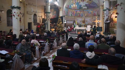 Cristãos palestinos participam da missa da véspera de Natal na Igreja Católica da Sagrada Família na Cidade de Gaza