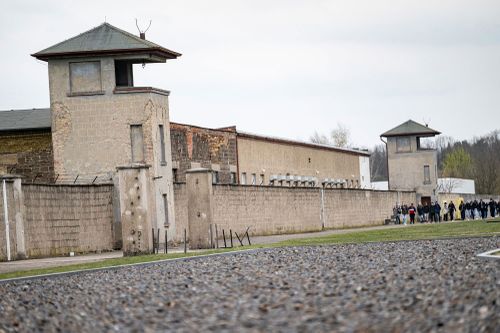 Люди идут по территории бывшего концентрационного лагеря у мемориала Заксенхаузен.