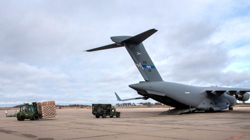 Lithuania's military loads Stinger anti-aircraft systems and body armour vests into a military cargo plane bound for Ukraine.