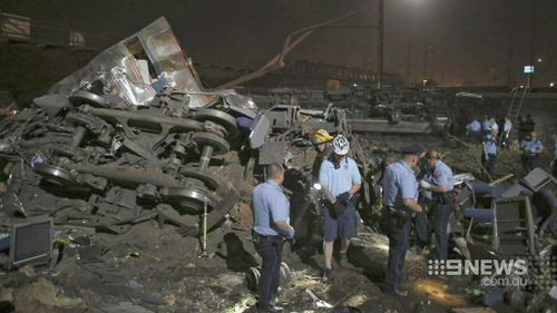 Investigators scour the wreckage of the crashed train. (9NEWS)