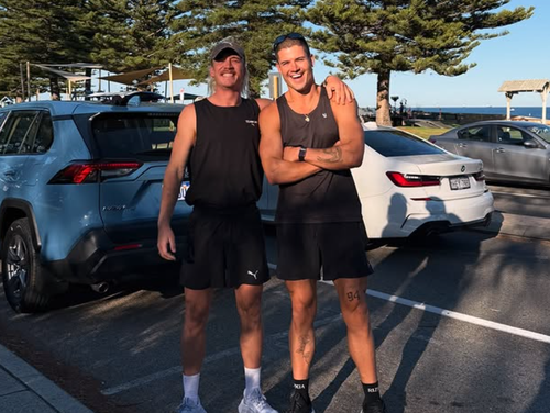 William Goodge (right) and runner Ned Brockman pose at Cottesloe Beach in Western Australia.