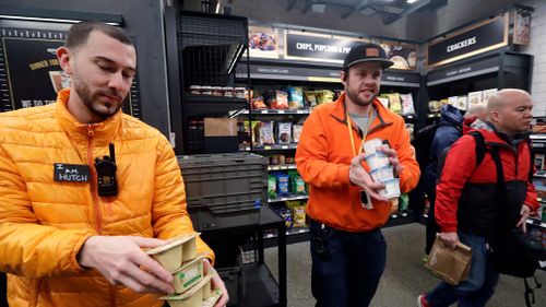 Store employees Tyler "Hutch" Hutchinson, left, and Eric Halgren stock shelves at an Amazon Go store. (AAP)