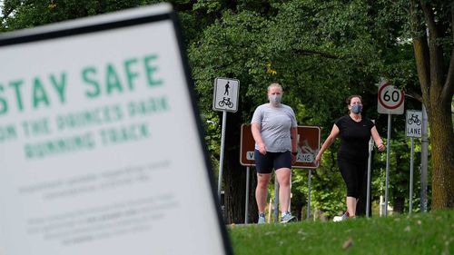 People go for a run along the Princes Park track in Melbourne.