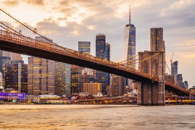 New York City skyline at sunset with Brooklyn Bridge and Lower Manhattan. Image shot from Brooklyn.