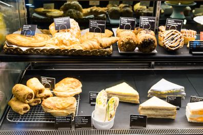 Variety of tasty pastry in glass display Australian Bakery