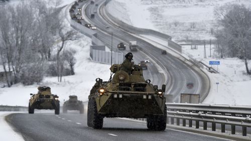 FILE - A convoy of Russian armored vehicles moves along a highway in Crimea, Tuesday, Jan. 18, 2022. A buildup of an estimated 100,000 Russian troops near Ukraine has fueled Western fears of an invasion, but Moscow has denied having plans to launch an attack while demanding security guarantees from the the U.S. and its allies. (AP Photo/File)