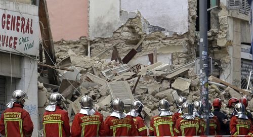 Firefighters work at the scene where buildings collapsed in Marseille.