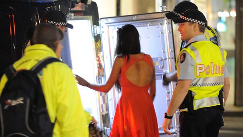 An intoxicated woman is taken into police custody in Melbourne