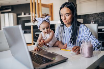 Mother and baby girl working on laptop. Working mother concept