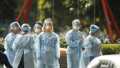 Workers in personal protective equipment at one of the nine public housing estates are in mandatory lockdown in Melbourne. 