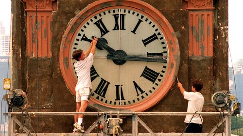 Daylight saving finishes this weekend with the clocks being put back one hour.Pic Shows; Painter, Wayne Fleming of Minchenbury working on the Balmian Post Office Tower clock, playfully trys to stop time while co-worker, David Hamilton works on.