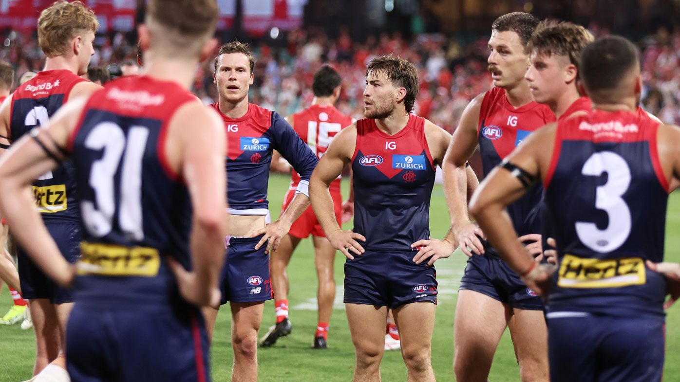 Melbourne Demons players react to their Opening Round loss to the Sydney Swans.