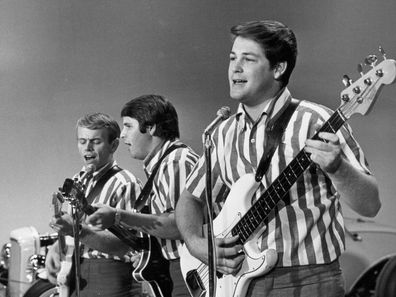 NEW YORK - SEPTEMBER 27: Al Jardine, Carl Wilson and Brian Wilson of the rock and roll band "The Beach Boys" perform the song "I Get Around" onstage on "The Ed Sullivan Show" in front of vintage hot rod cars on September 27, 1964 in New York City, New York. (Photo by Michael Ochs Archives/Getty Images)