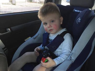 Spencer McPherson in his car seat on the way to hospital.