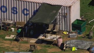 A makeshift awning and some chairs can be seen outside the shipping container Dezi Freeman was hiding inside.