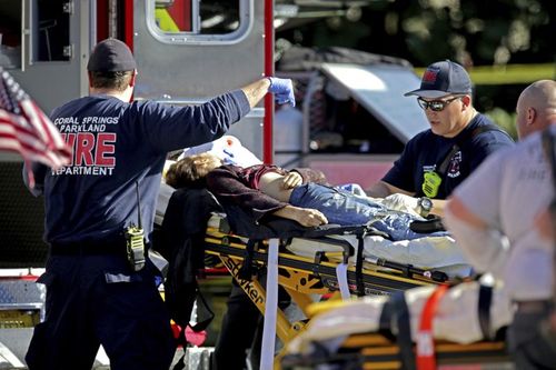 A shooting victim is carried away on a stretcher on the day of the tragedy. (AAP)