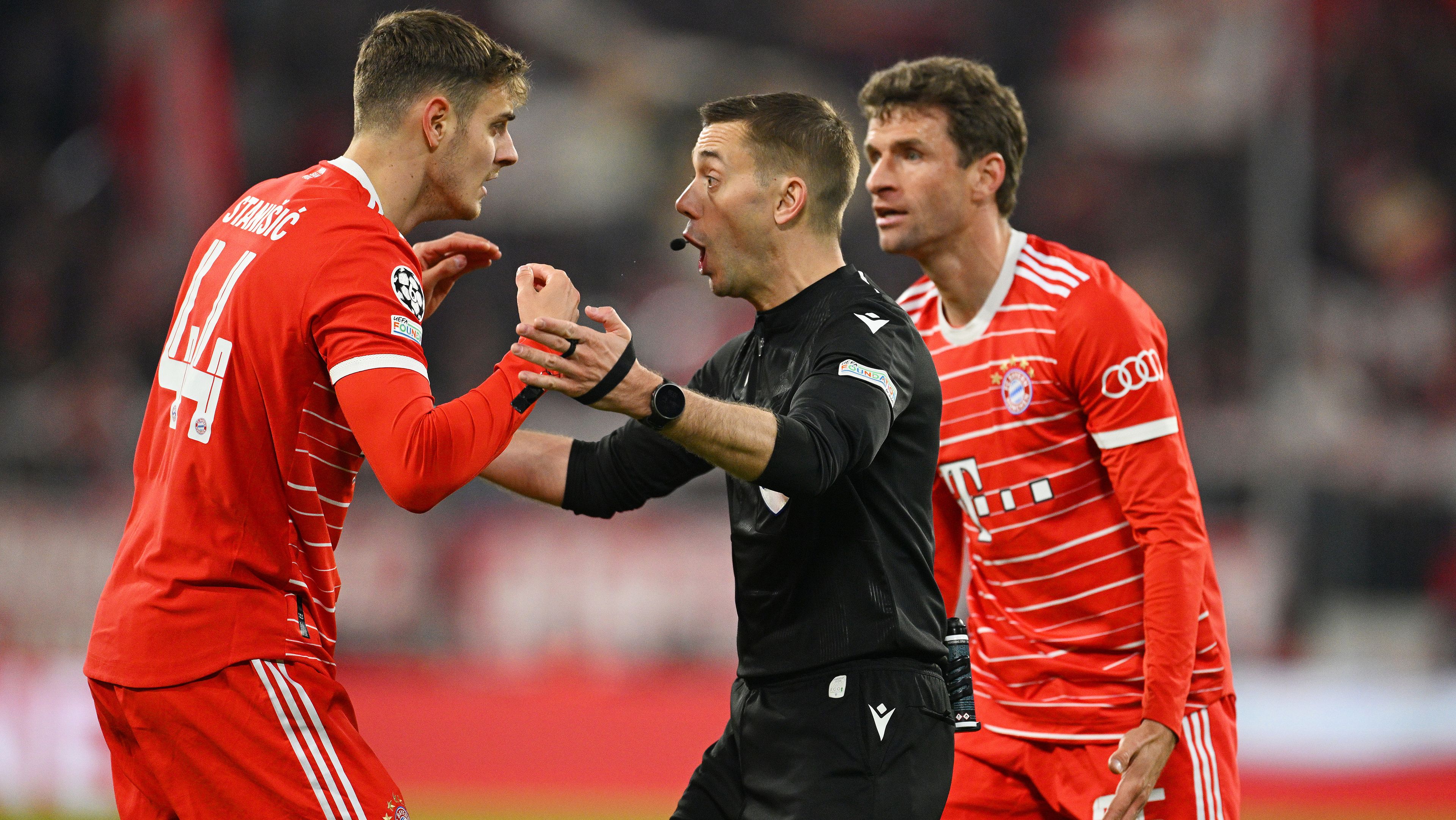 Josip Stanisic and Thomas Muller of Bayern Munich react towards referee Clement Turpin.