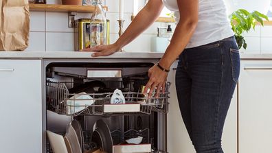 Woman doing housework and emptying dishwasher