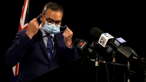 South Australian Premier Steven Marshall takes his mask off to brief the media on COVID-19. 