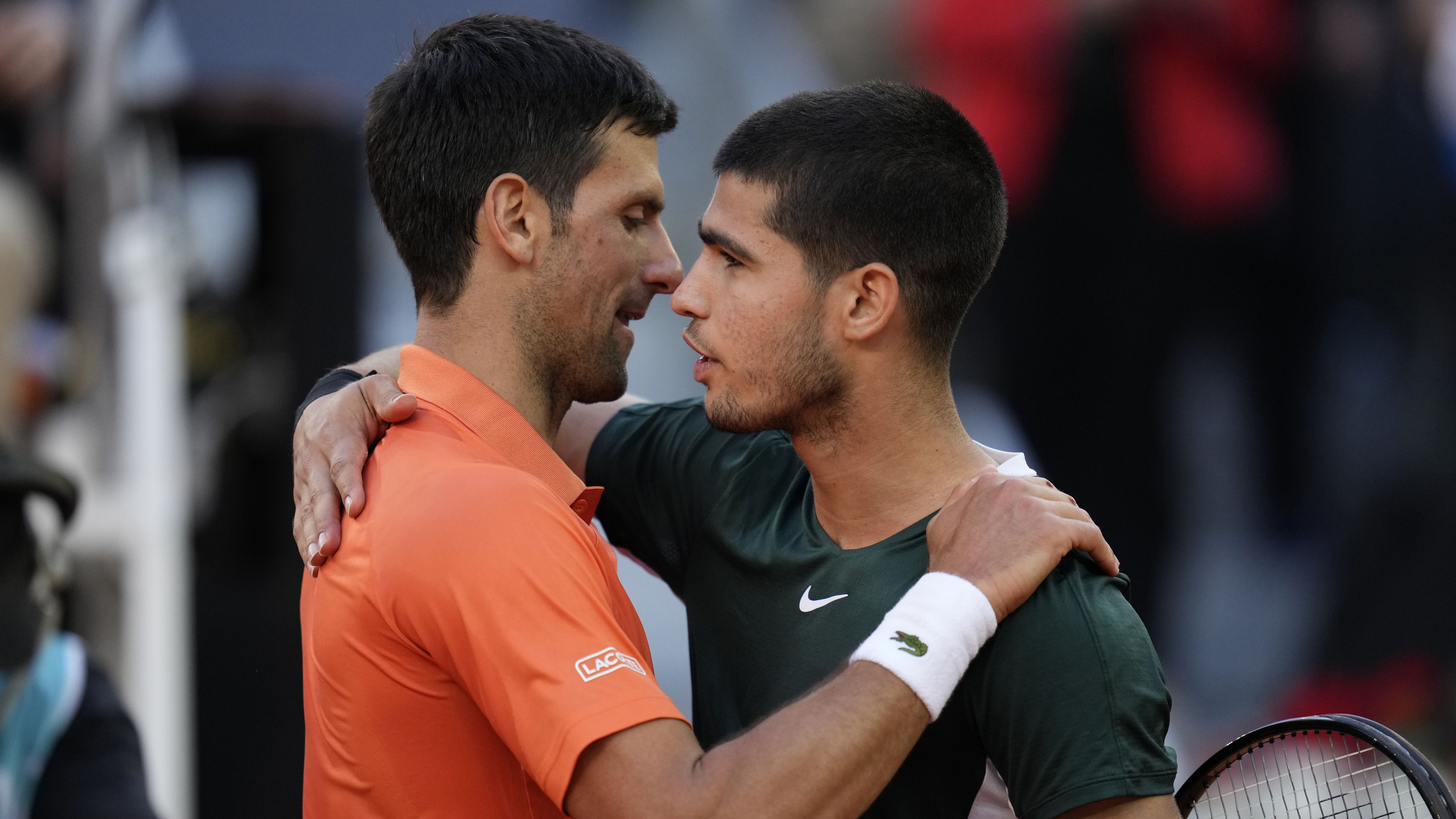 Novak Djokovic embraces Carlos Alcaraz at the Madrid Open.