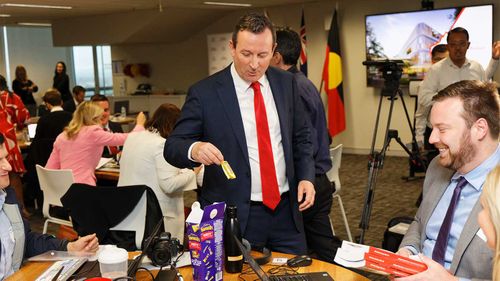 WA Premier Mark McGowan looks thrilled after reaching into a box of Favourites and getting a Flake during the budget lockup yesterday.