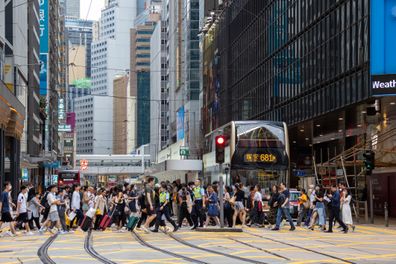 Hong Kong - Pedestrians walk past the Des Voeux Road Central in Central, Hong Kong.