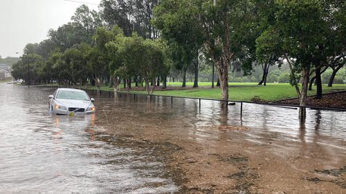 A car is swallowed by water after heavy rain caused flash flooding in Canterbury. 