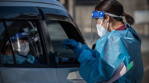  A nurse collects a nasal swab sample from a car driver at a Covid-19 coronavirus PCR testing centre at Fujimino Emergency Hospital on December 18, 2020 in Miyoshi-machi, Japan